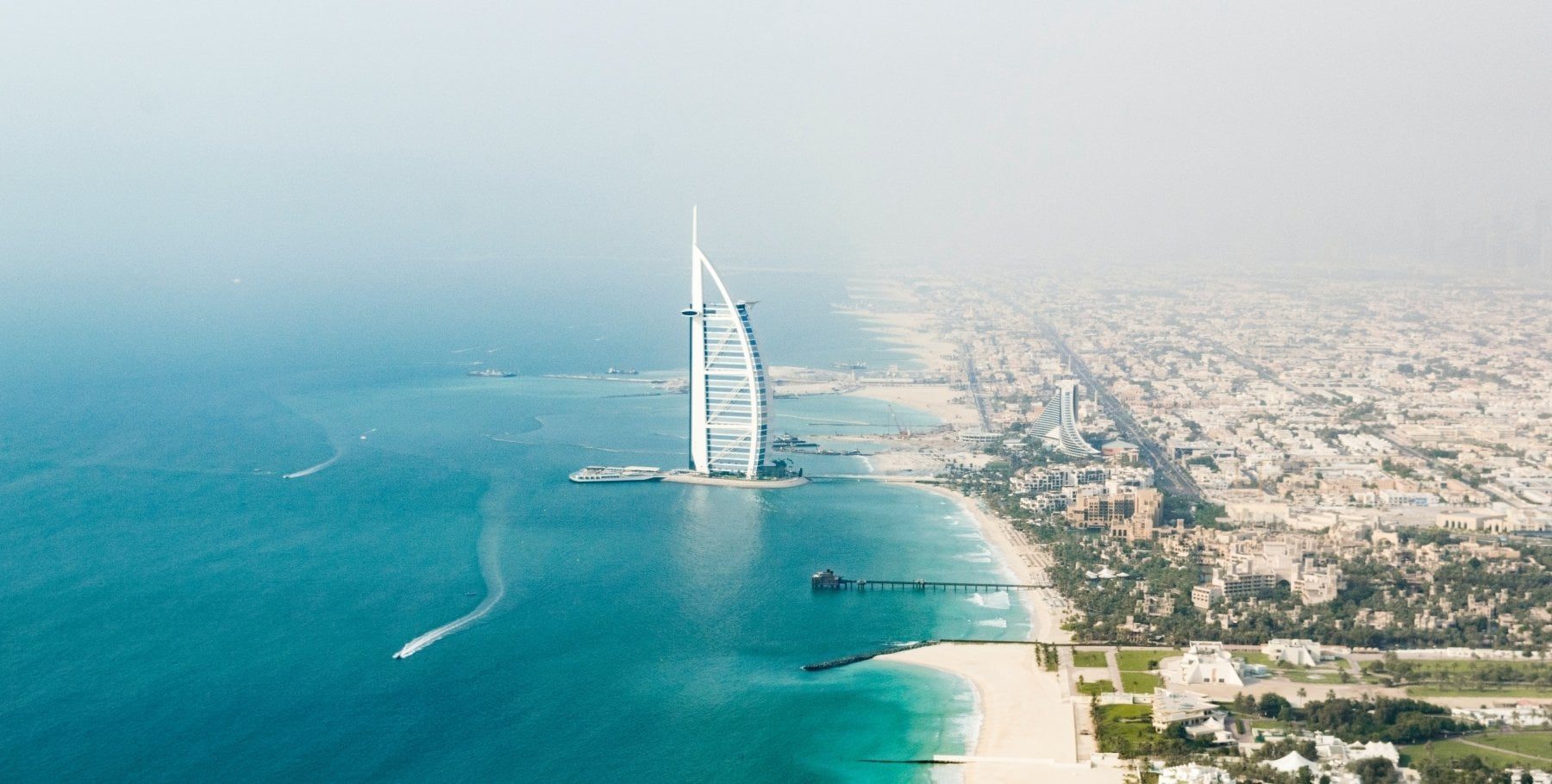 Aerial view of Dubai coastline with Burj Al Arab surrounded by sea and beachfront