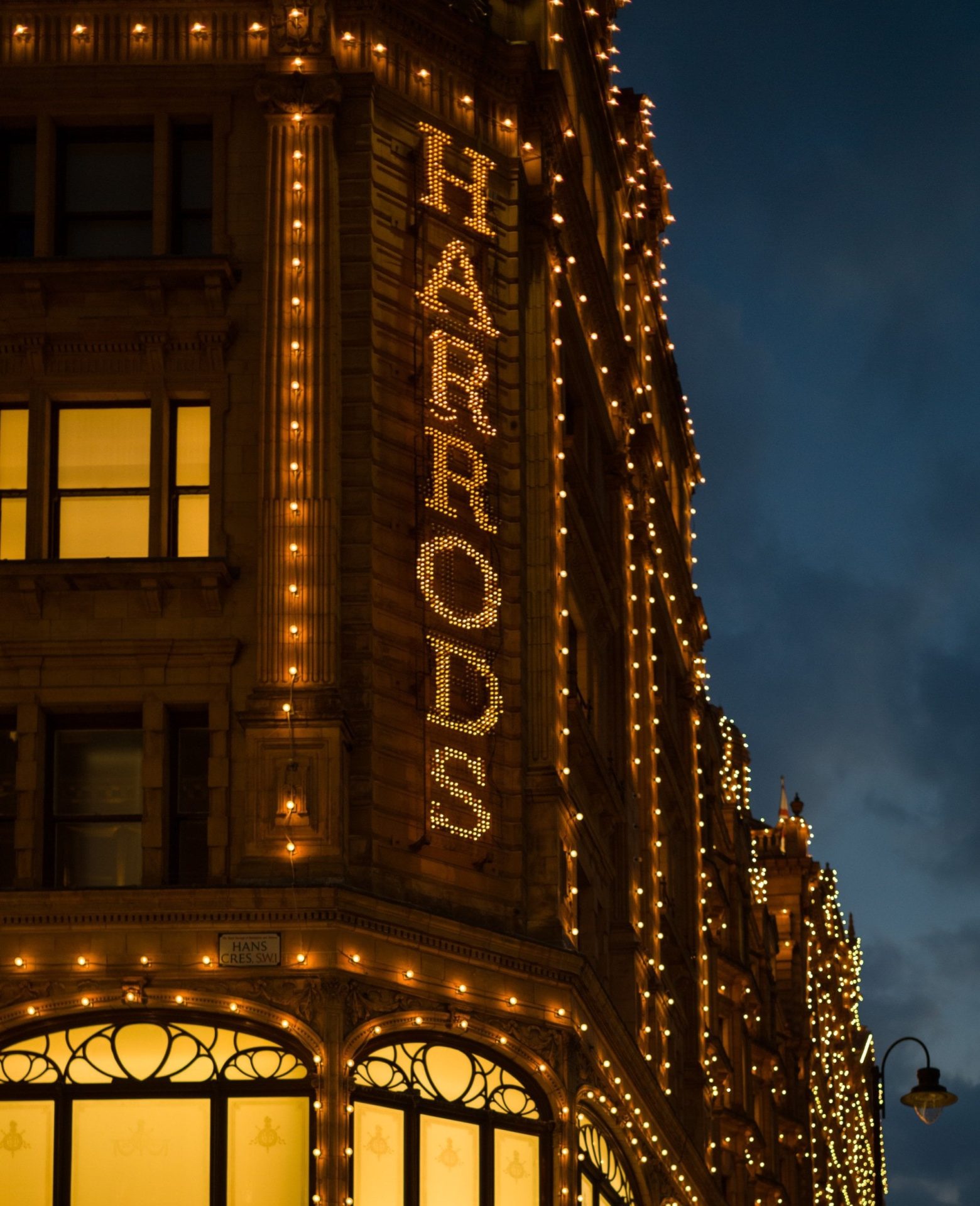 Harrods department store exterior illuminated at night in Knightsbridge, London