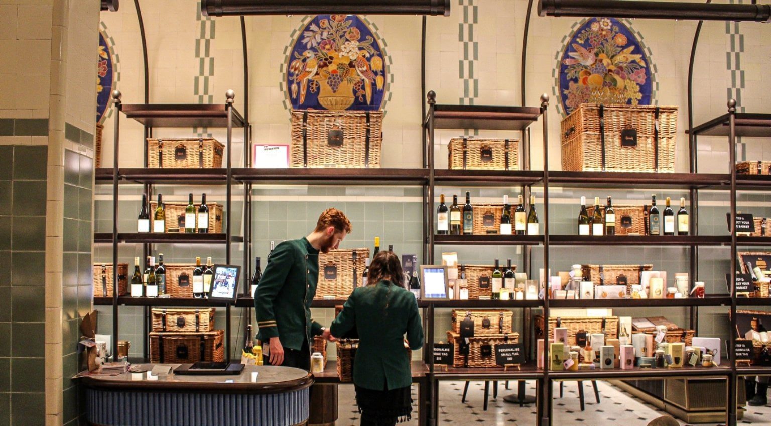 Interior of Harrods food hall with luxury displays and staff assisting customers