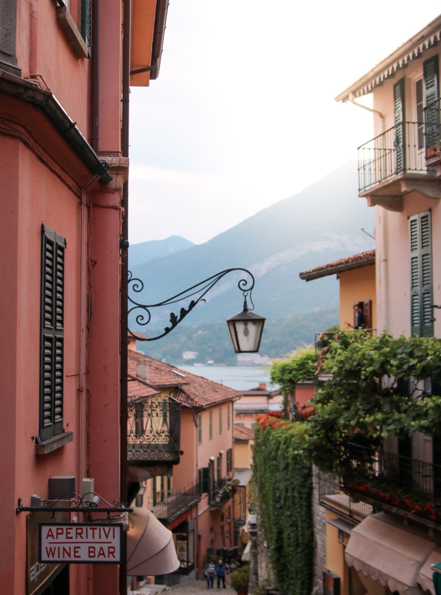 Traditional Italian village street near Lake Garda with pastel buildings and mountain views