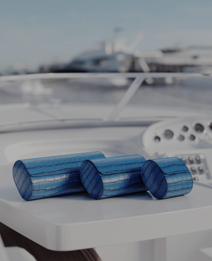 Luxury crocodile-embossed leather watch rolls displayed on a yacht deck
