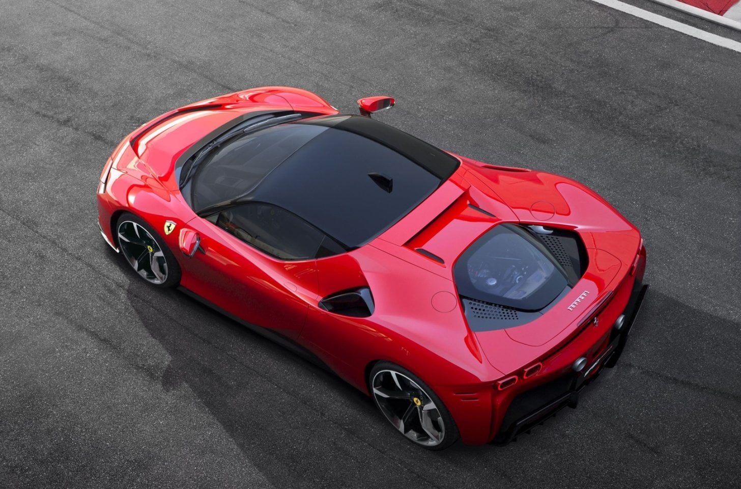 Aerial view of a red Ferrari supercar parked on asphalt