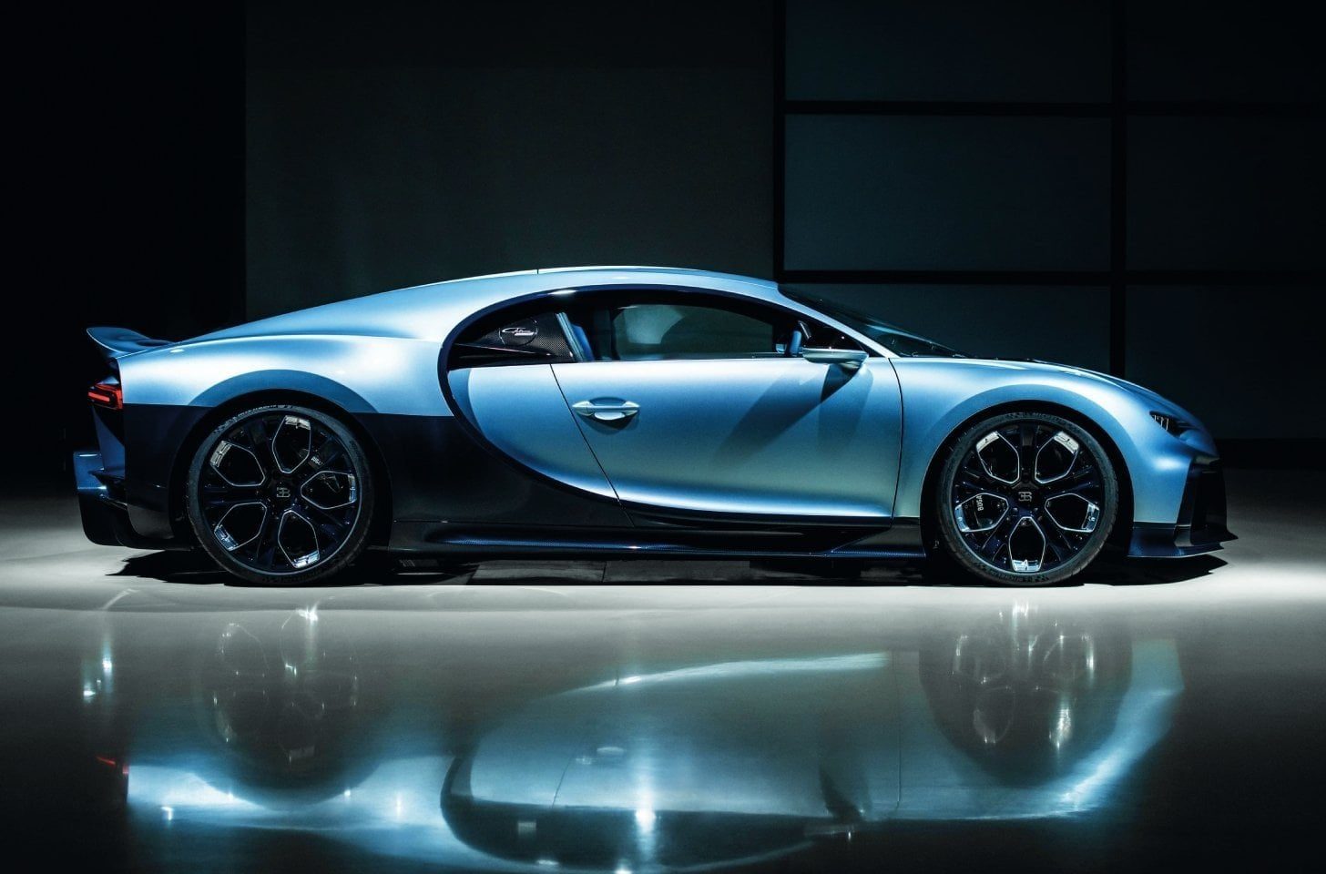 Side profile of a blue Bugatti sports car highlighting its aerodynamic body shape