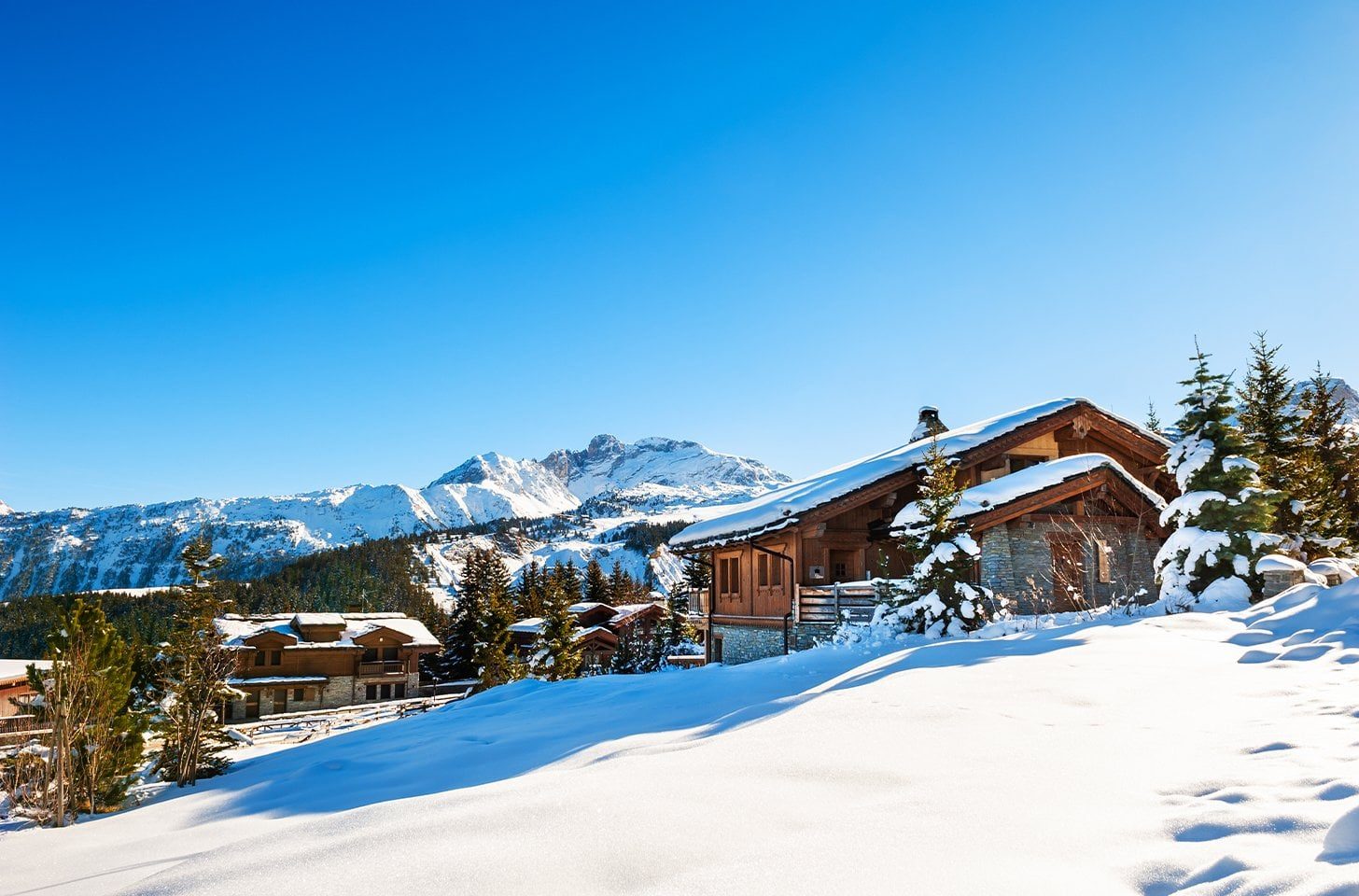 Luxury ski chalets in Courchevel surrounded by fresh snow and pine trees