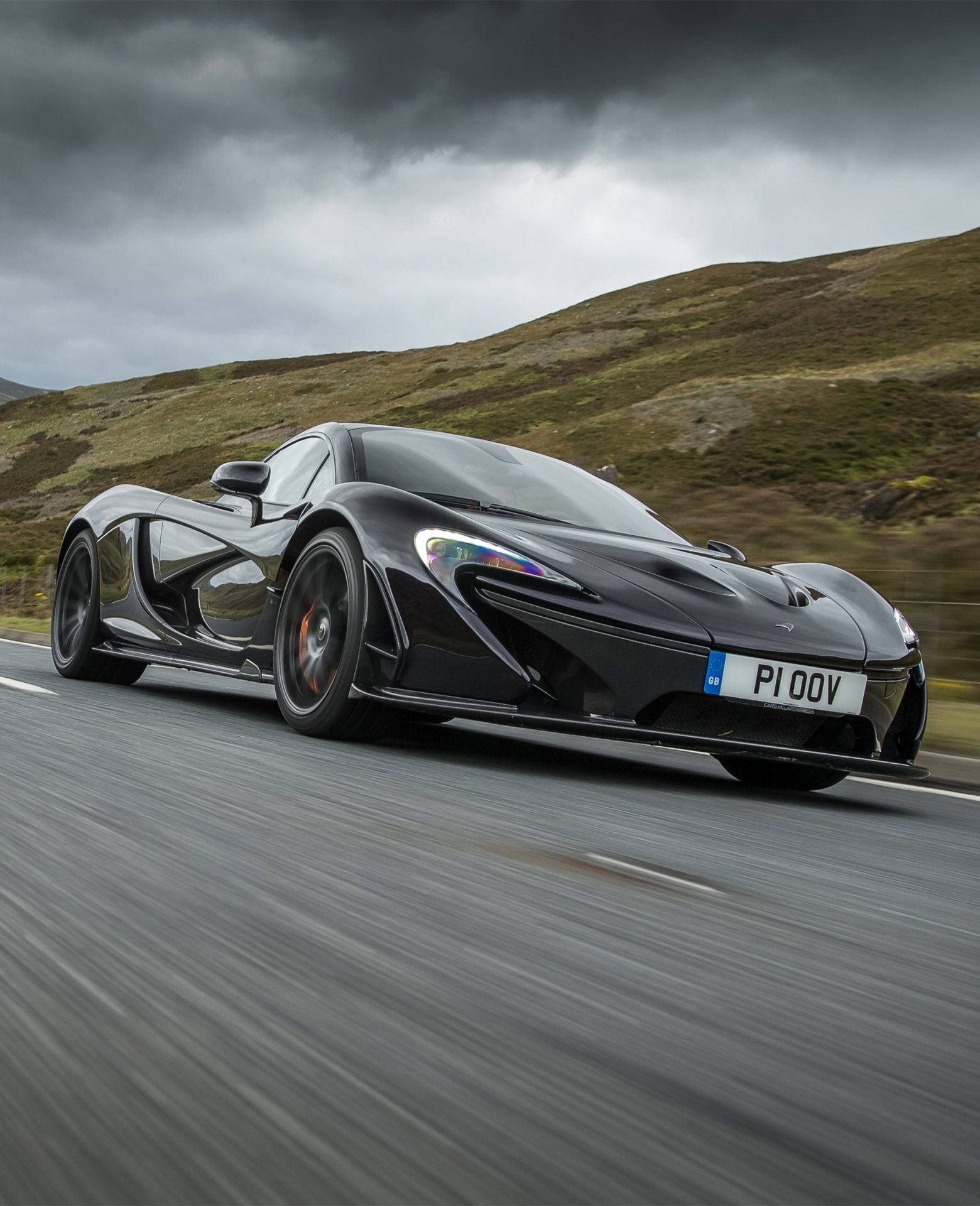 McLaren P1 hypercar driving through countryside, showcasing aerodynamic performance