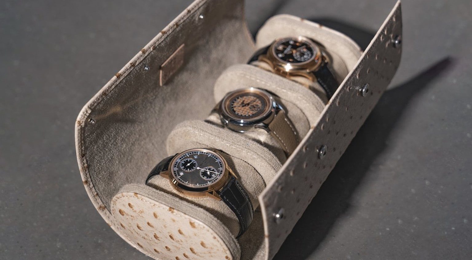 Interior view of an ostrich leather watch roll showcasing soft lining and secure compartments for multiple watches