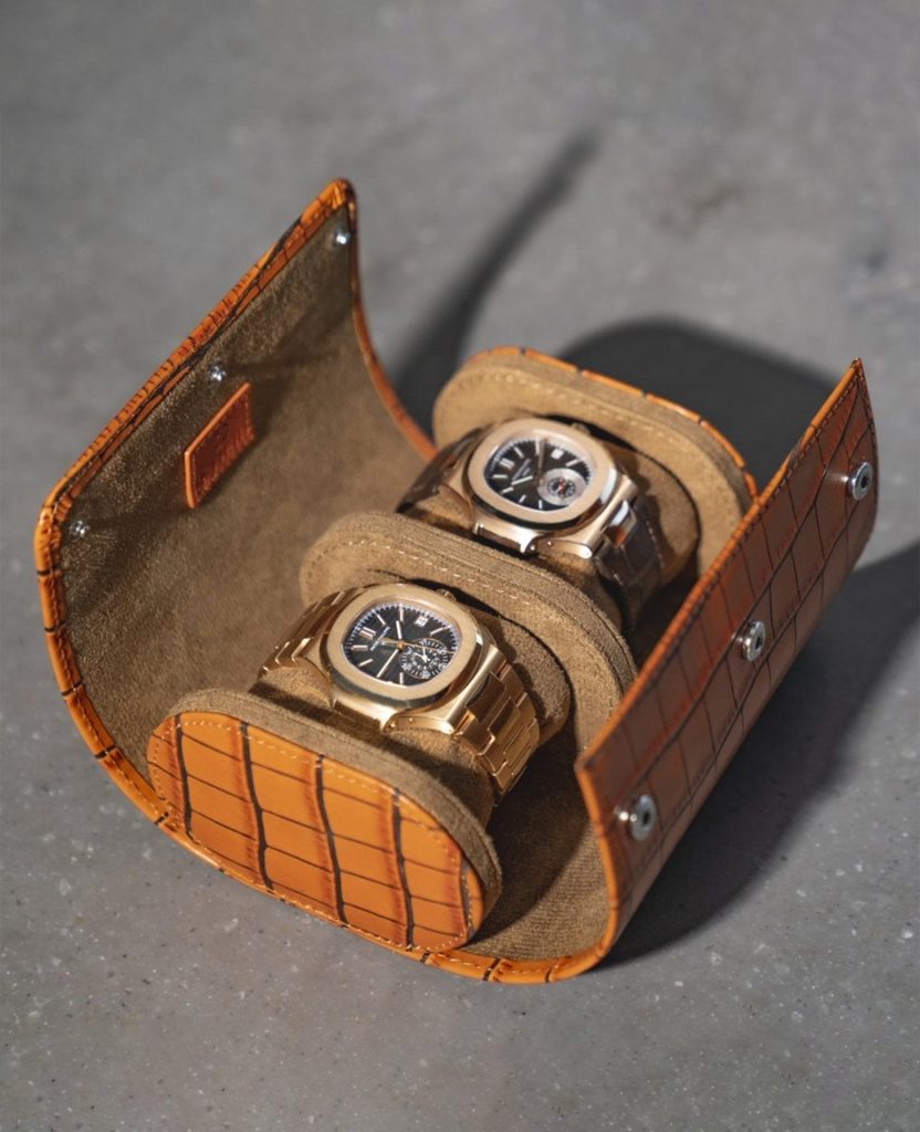 Luxury watch rolls and protection holding two timepieces, displayed on a Rolls-Royce bonnet